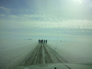 A small group of people cross the snow-shrouded prairie
